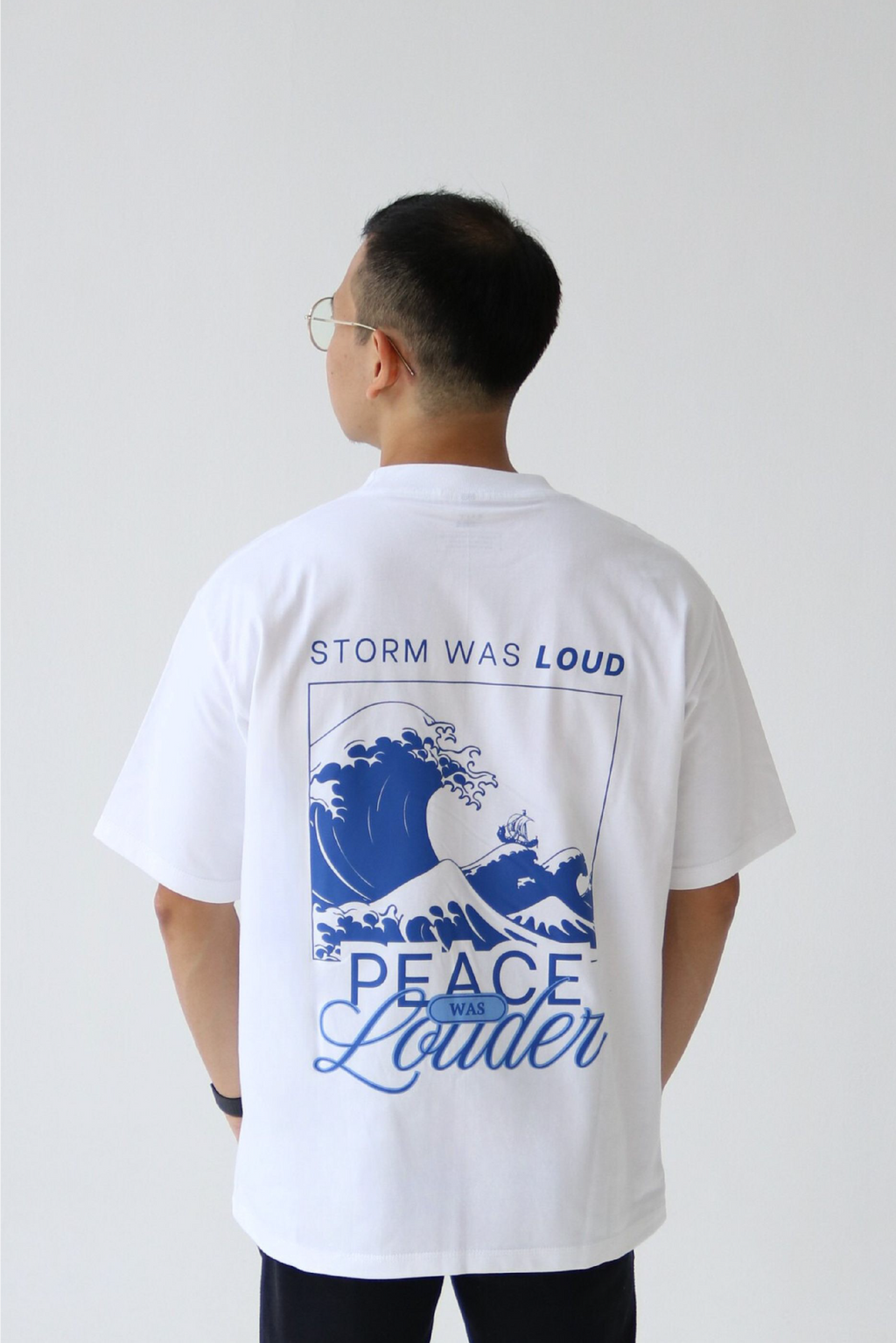 Oversized graphic white T-shirt back design - "Storm was loud, peace was louder"