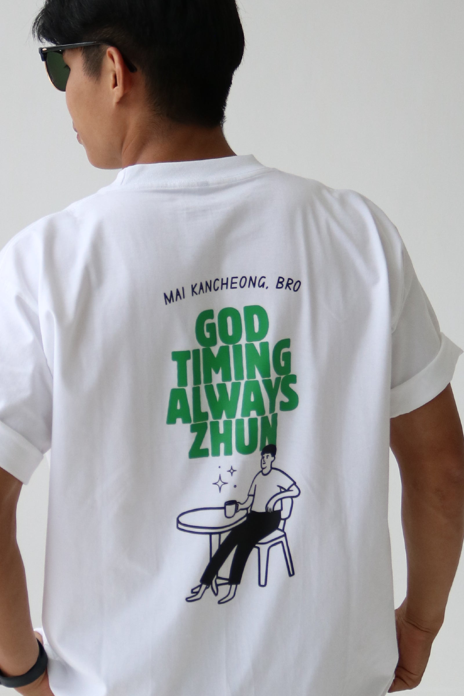 Oversized graphic white T-shirt back design - "Mai kancheong, bro, God timing always zhun"